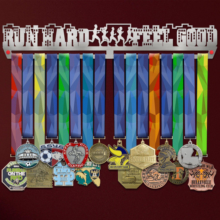 Run Hard Feel Good Medal Hanger Display holding colorful ribbons and various sports medals, ideal for runners and athletes.